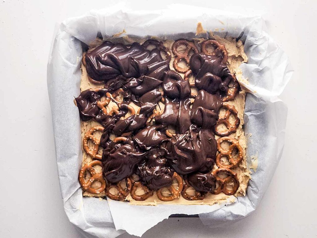 Chocolate poured over the top of the pretzels and batter in the baking pan.