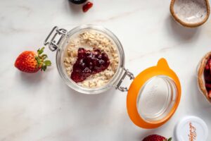 Fruit spread added to overnight oats in a canning jar.