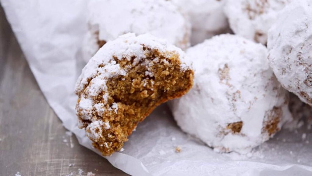 The finished Pfeffernusse Cookies in a pile. One has a bite taken out of it.