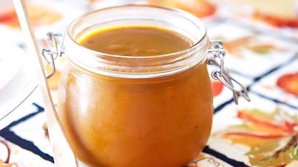 An open canning jar filled with pumpkin butter.