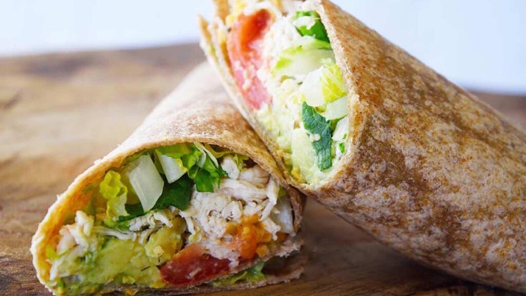 The finished Ranch Chicken Wraps Recipe. The wrap is stacked and sitting on a cutting board.