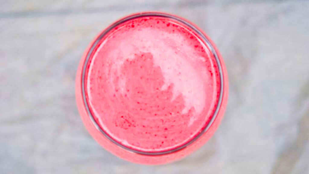 An overhead view of a glass filled with Raspberry Coconut Smoothie.