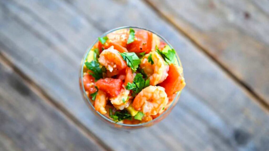 A glass filled with Shrimp Campechana, shown from overhead.