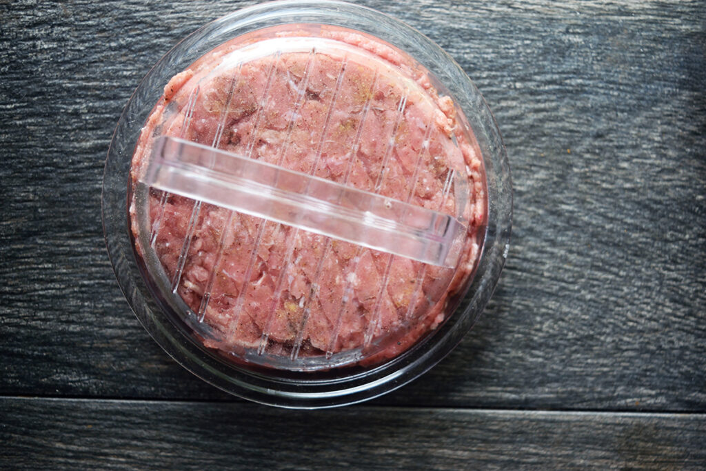 Ground turkey meat in a burger press.