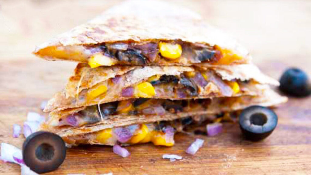 Stuffed Mexican Quesadillas stacked on a cutting board.