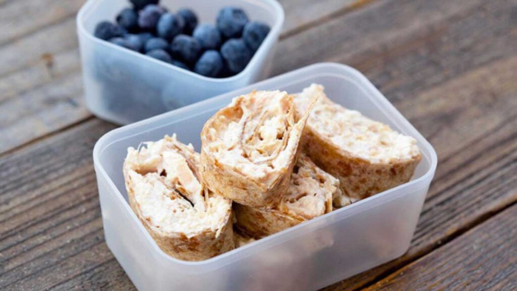 Tuna Pinwheels in a bento container. Another bento box with fresh blueberries sits next to it.