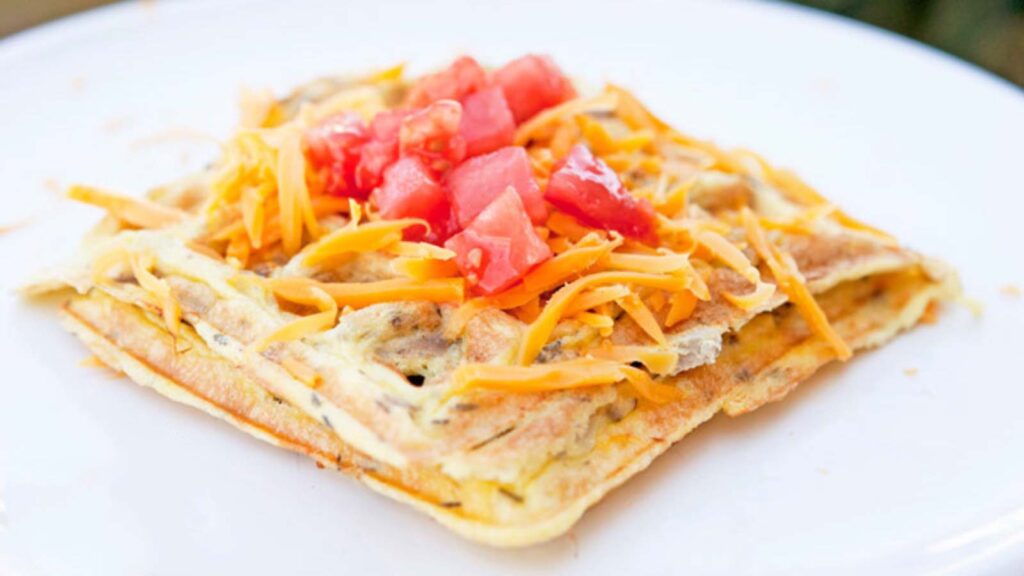 Waffle Iron Omelets topped with cheese and tomatoes.