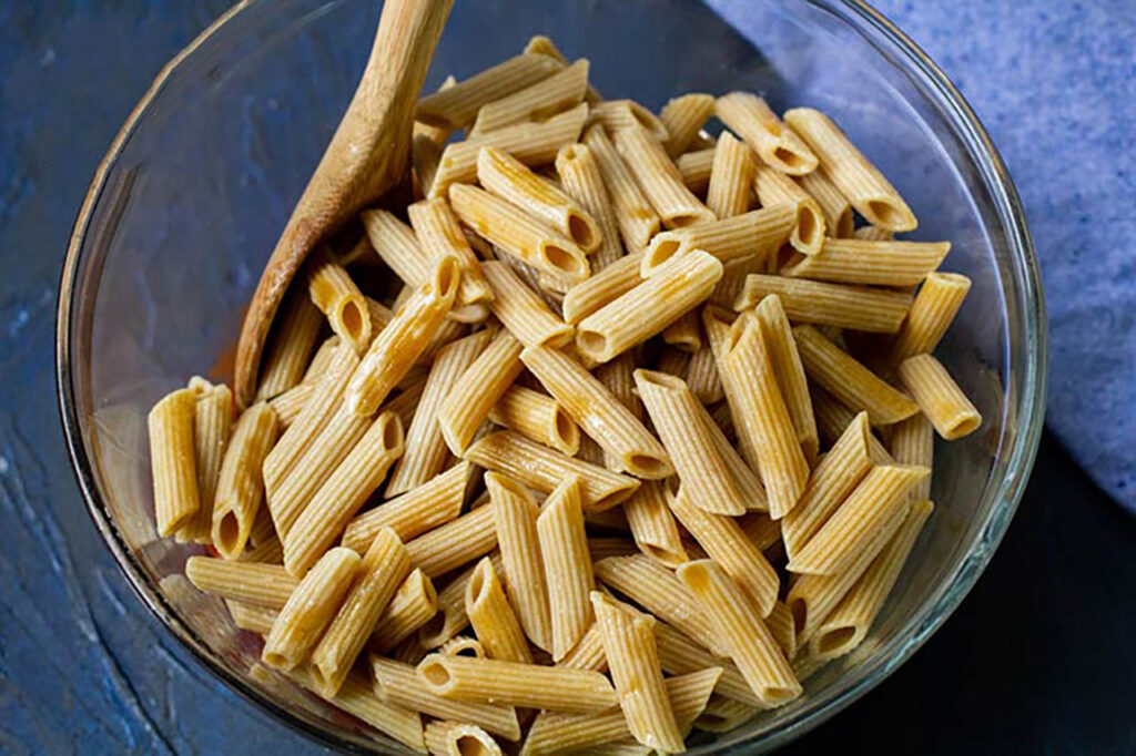Cooked pasta in a glass mixing bowl.