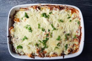 A just-baked ziti garnished with fresh, chopped basil.