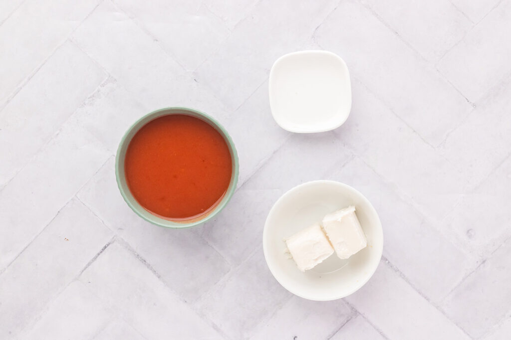 Buffalo sauce ingredients in bowls on a white counter.