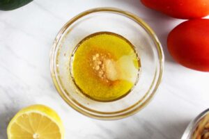 Dressing ingredients for this Mediterranean Bowl combined in a small, glass bowl.