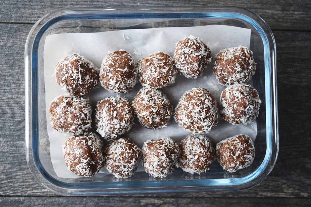 A second layer of Date And Oat Energy Balls laid out in a storage container.