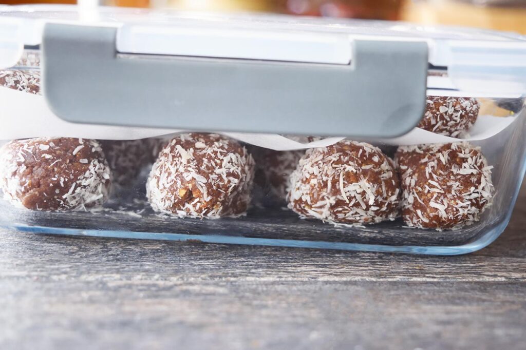 A side view of a storage container full of Date And Oat Energy Balls.
