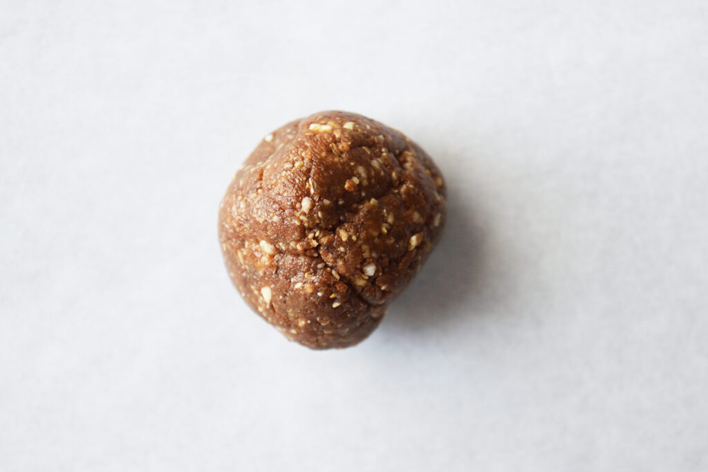 A closeup of rolled Date And Oat Energy Ball without coconut.