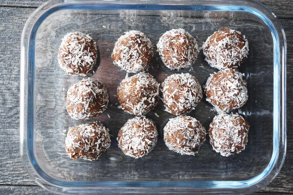 Date And Oat Energy Balls in a glass storage container.