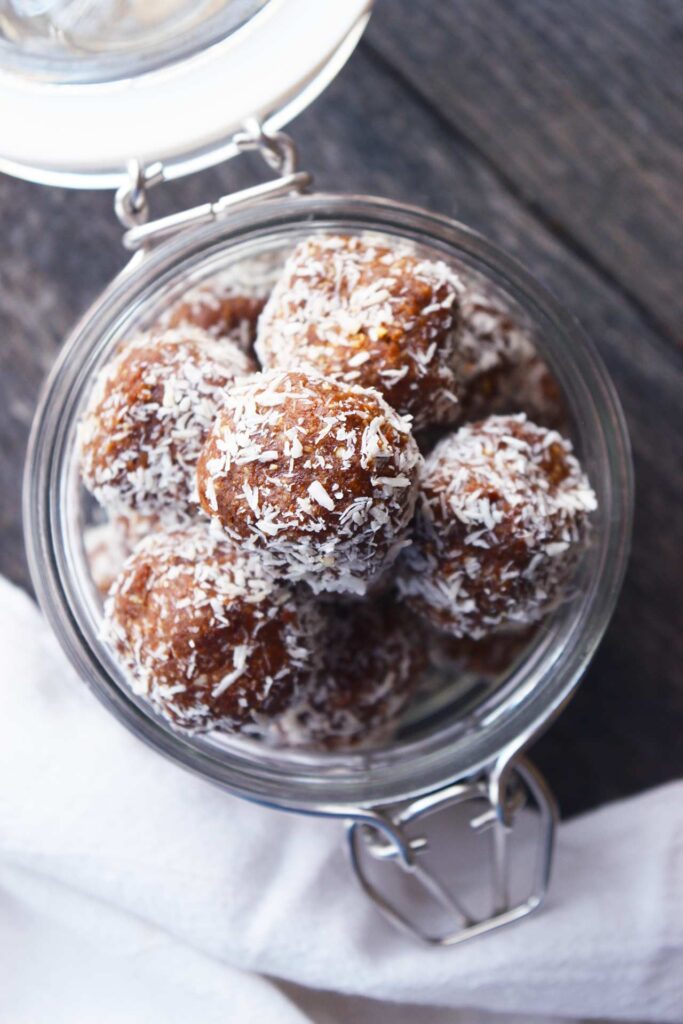 An overhead view of a glass jar full of Date And Oat Energy Balls.