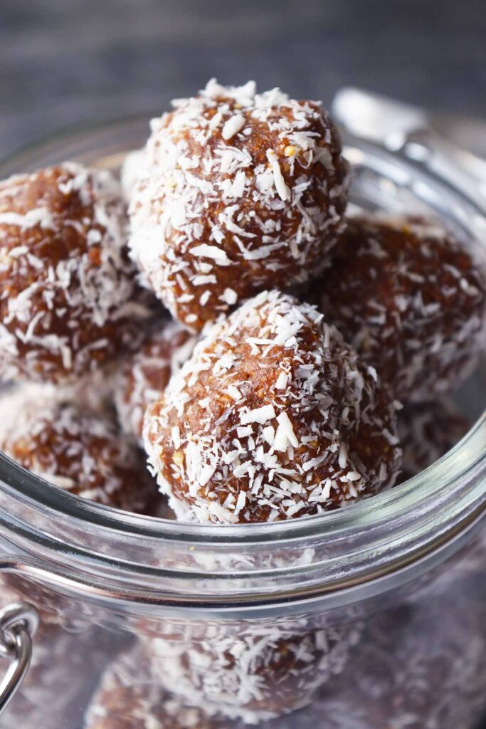 A front close-up of Date And Oat Energy Balls in a glass jar.