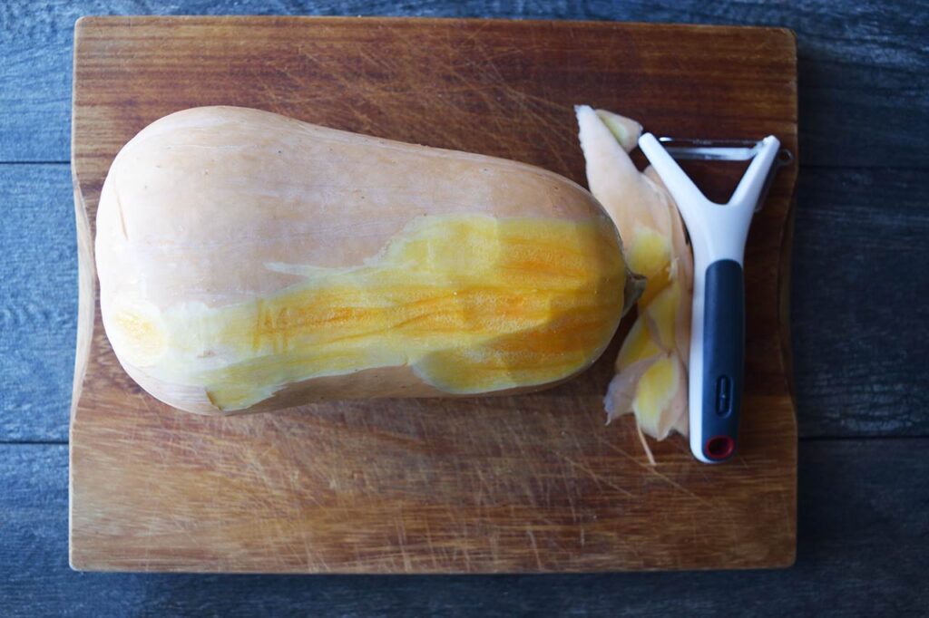 Peeling a fresh butternut squash.