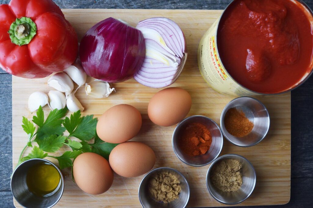 Shakshuka recipe ingredients gathered on a cutting board.