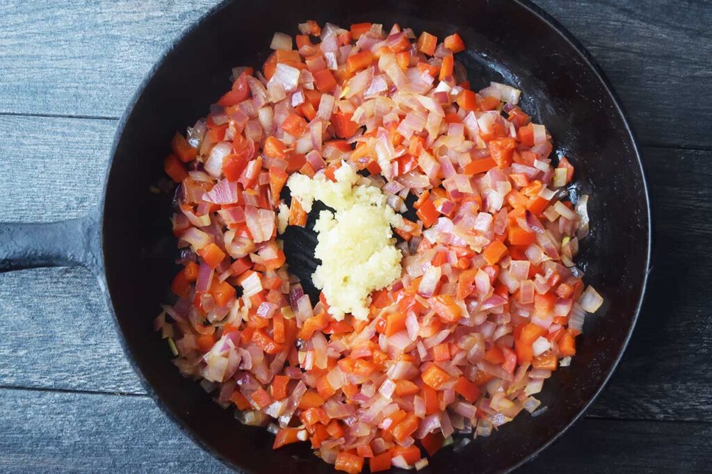 Pressed garlic added to sautéd, diced, bell pepper and onion.