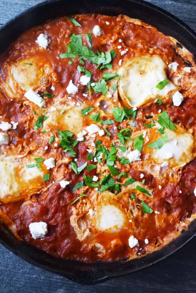 Freshly made and garnished Shakshuka in a cast iron skillet.