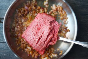 Ground meat added to sautéd onions.