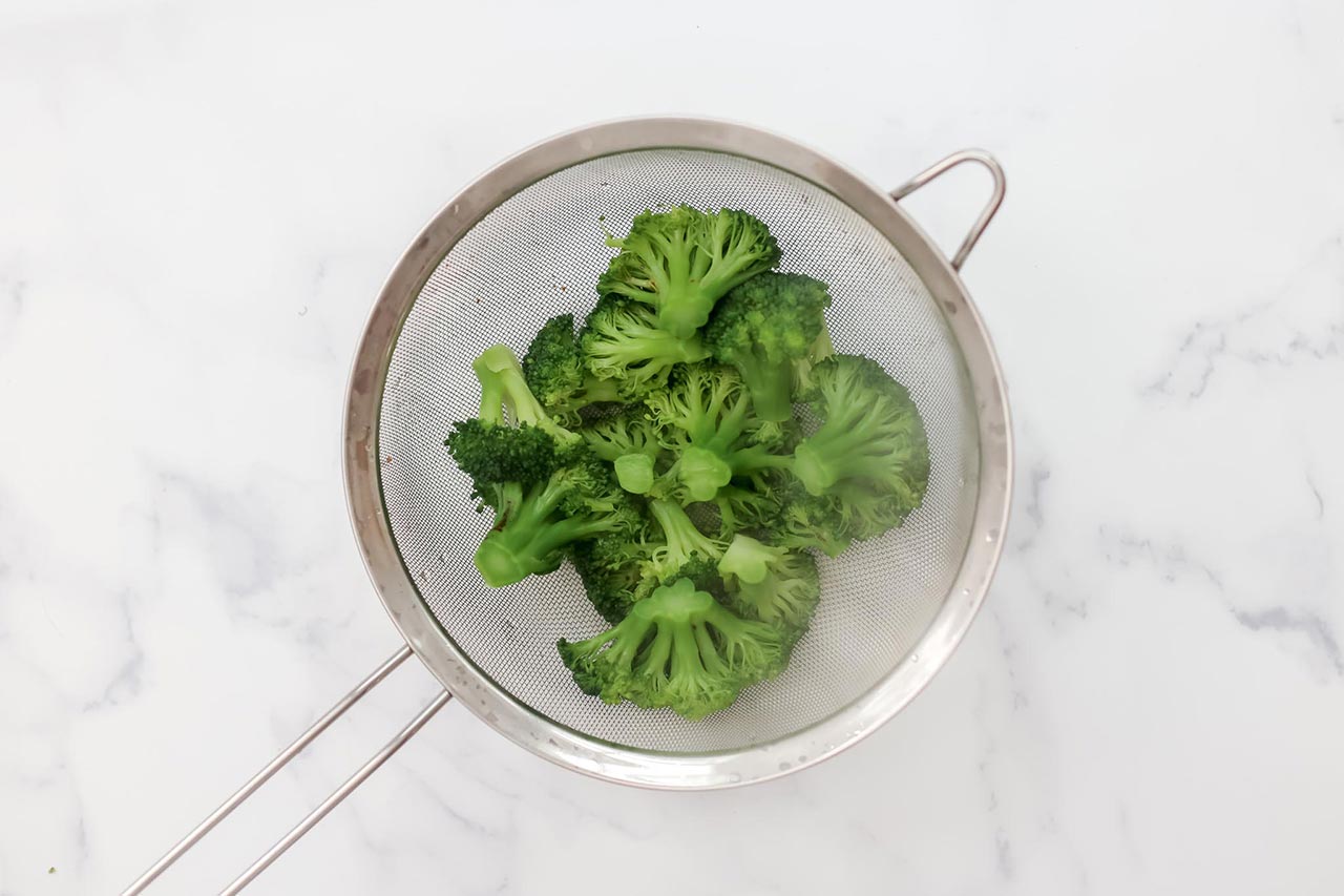 Boiled broccoli in a strainer.