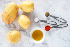 Air Fryer French Fries recipe ingredients on a white marble surface.