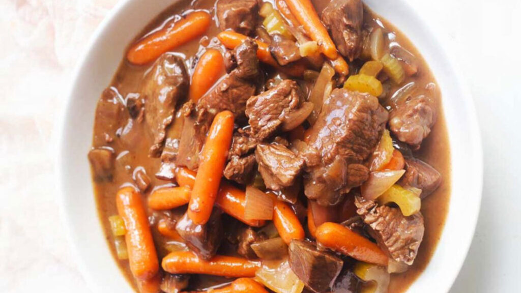 An overhead view of a white bowl filled with bison stew.