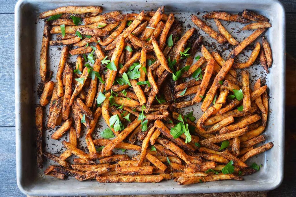 An overhead view of a baking sheet full of Cajun Fries.