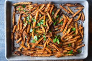 An overhead view of a baking sheet full of Cajun Fries.