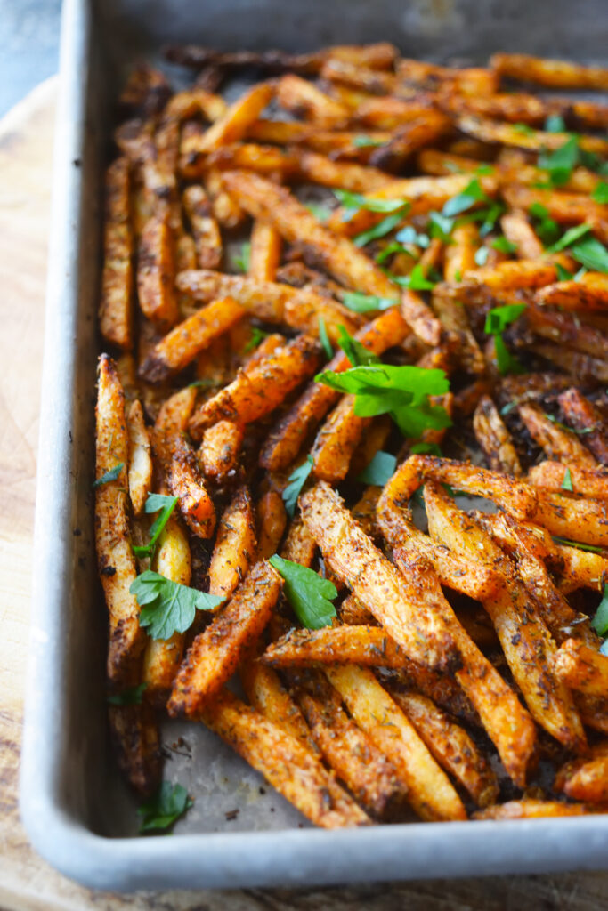A front view of a baking sheet full of Cajun Fries.
