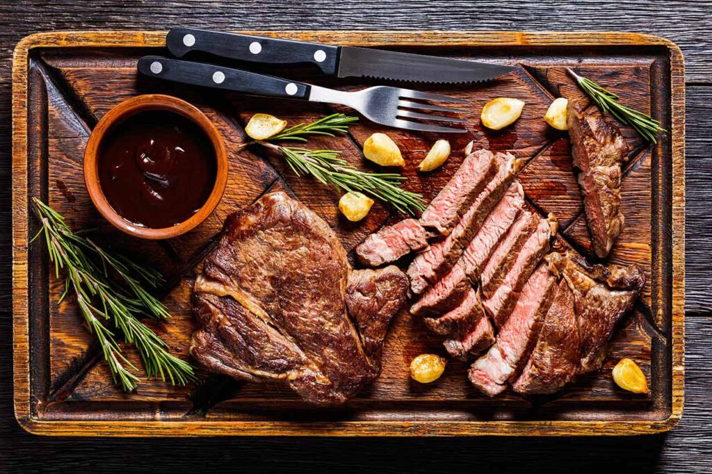 An overhead view of a chuck eye steak on a cutting baord.