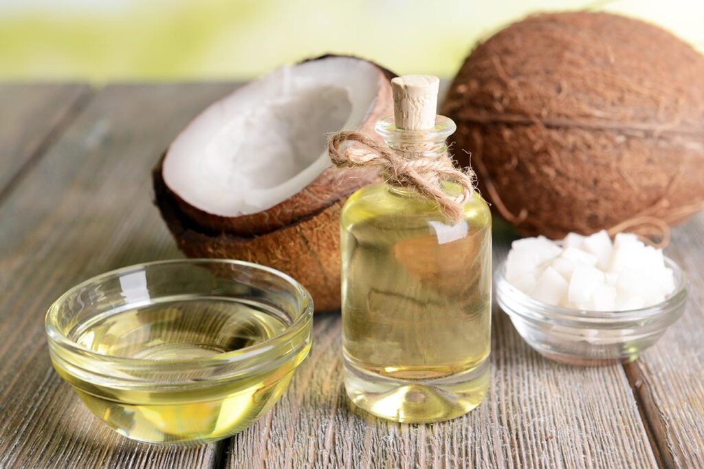 Coconut oil on table close-up next to a fresh coconut.