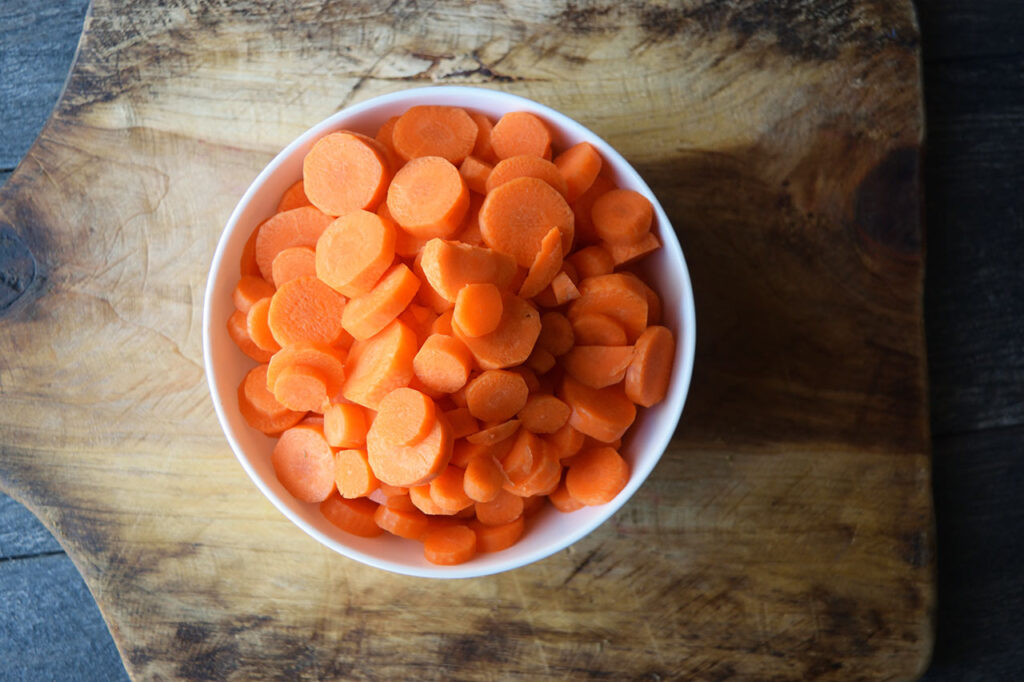 Sliced carrots in a white bowl.