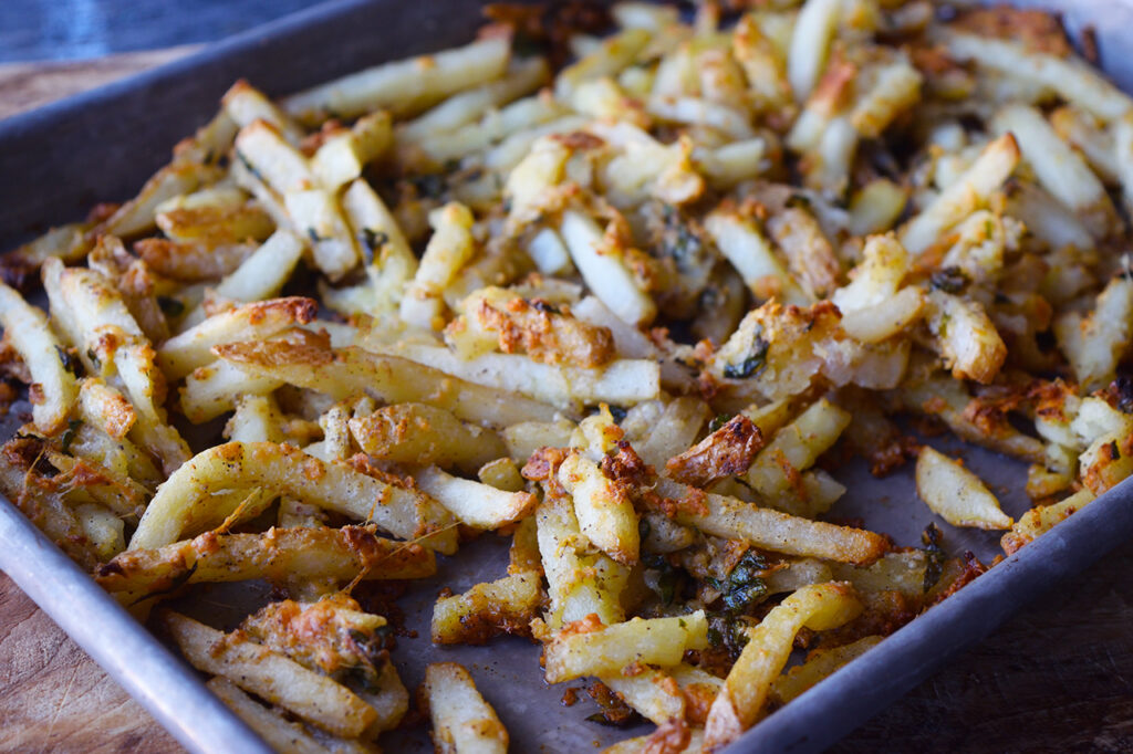 Garlic fries cooling on a baking pan.