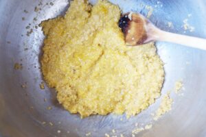 Gluten-Free Burger Bun ingredients mixed together in a mixing bowl with a wooden spoon.