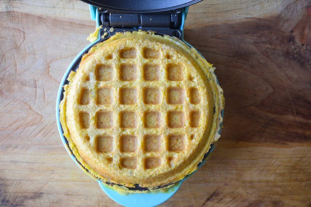 A cooked Gluten-Free Burger Bun sitting in the waffle maker.