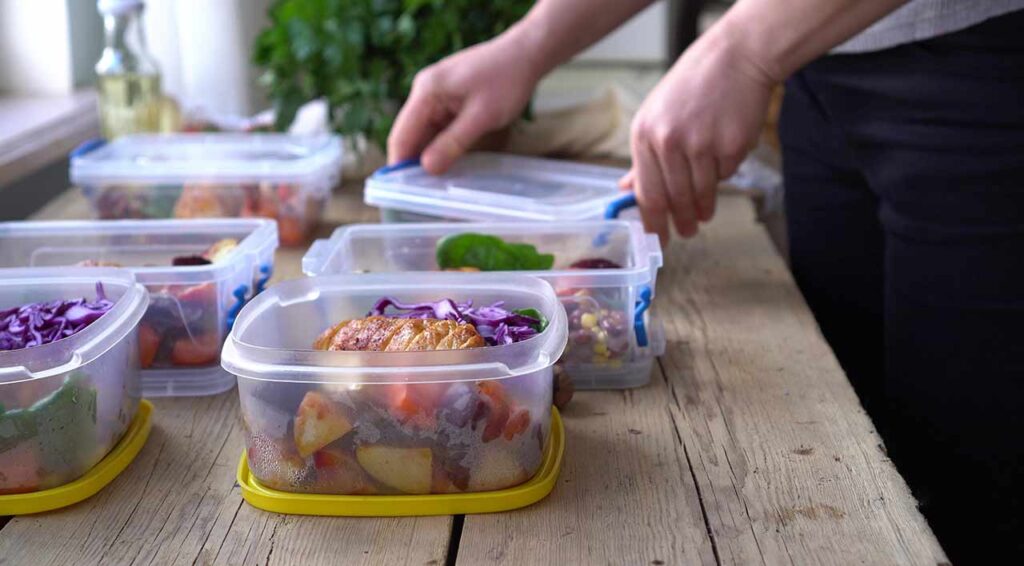 Meals being packed in individual meal prep containers.