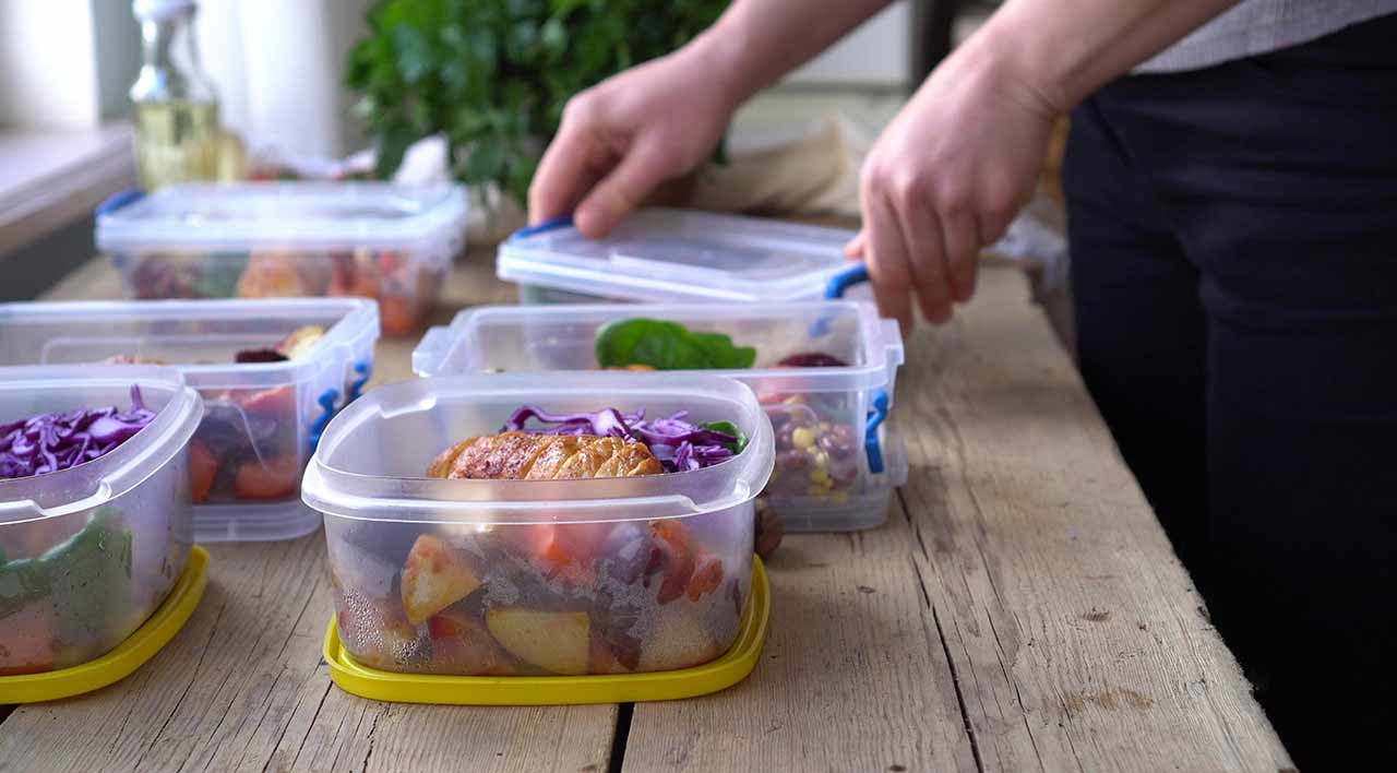 Meals being packed in individual meal prep containers.