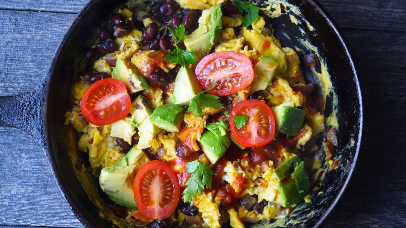 An overhead view of a black skillet filled with Mexican Scrambled Eggs.