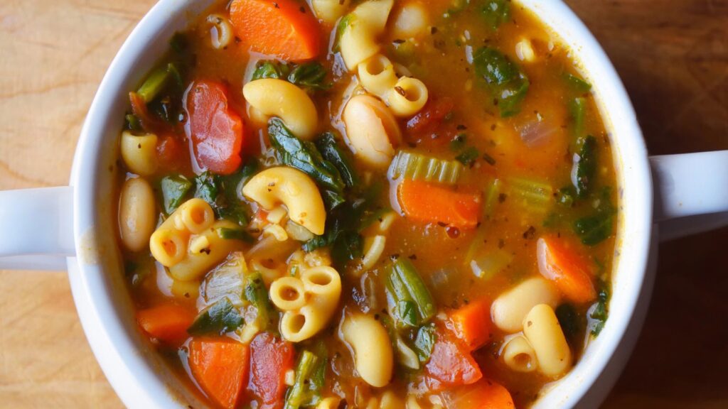 An overhead view of a white crock filled with Pasta Fagioli.