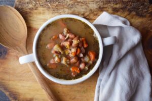 An overhead view of a white crock filled with Pinto Bean Soup.