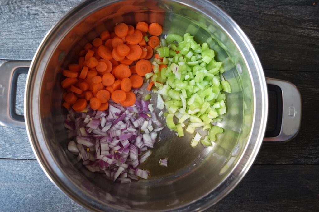 Cut, raw veggies in a large soup pot with oil.