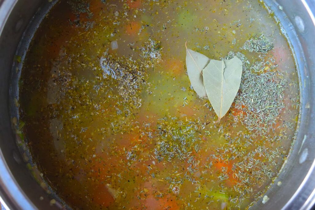 Bay leaves added to a pot of soup.
