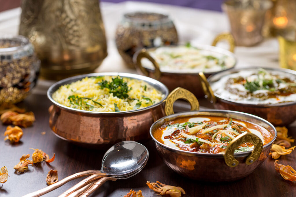 Pots of curry dishes and rice on a table.