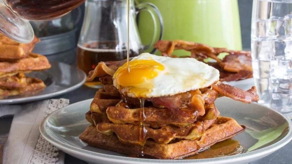 Cheddar waffles on a plate with a fried egg on top.