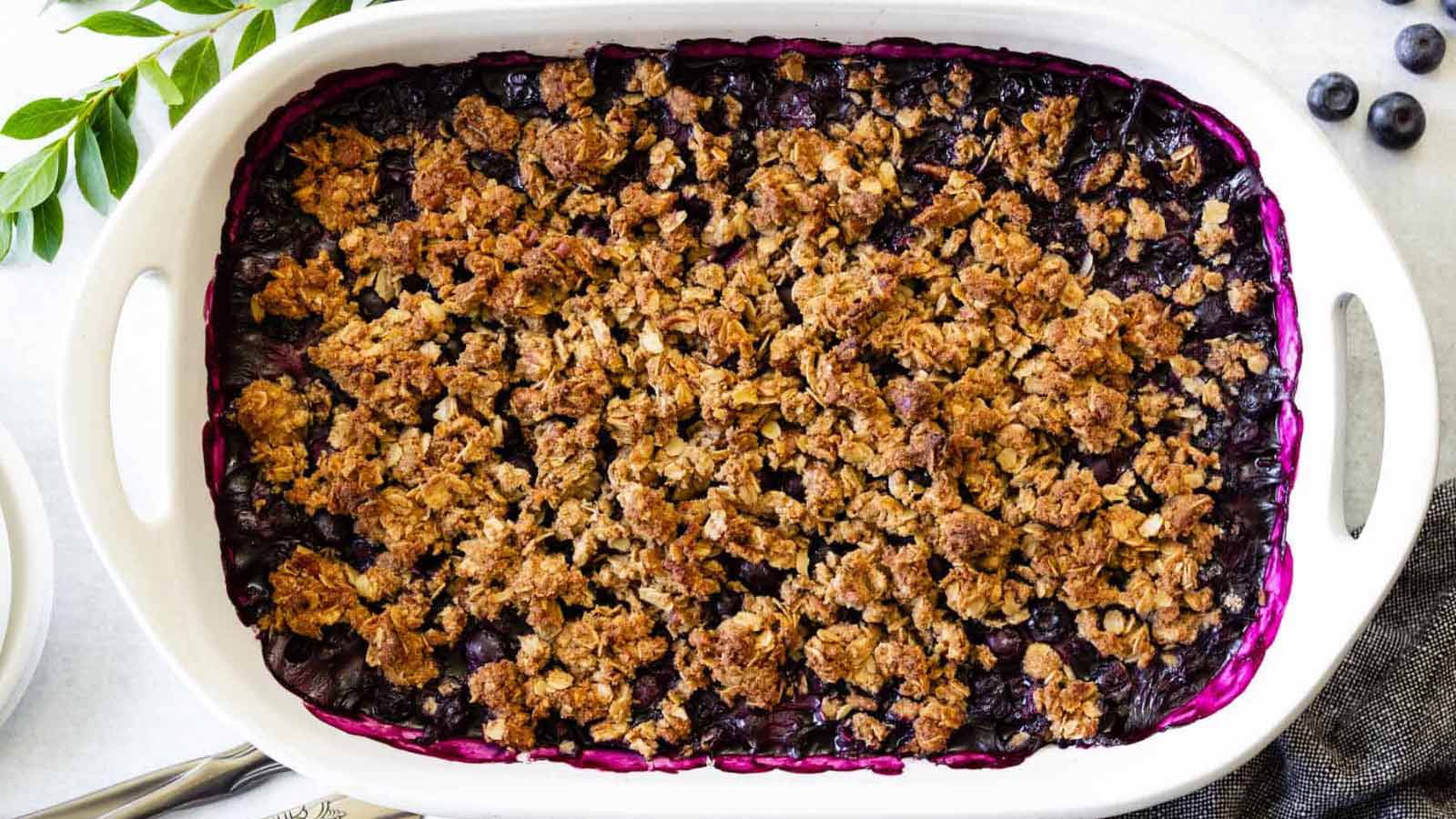 An overhead view of a gluten-free blueberry crisp in a white casserole.