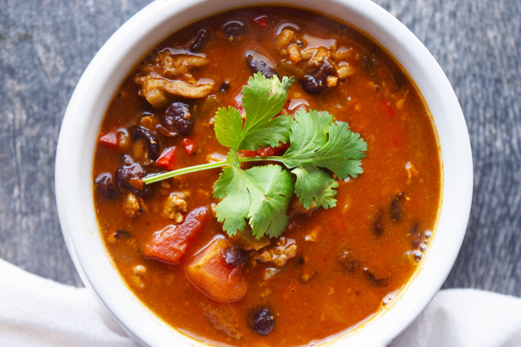 An overhead view of a white bowl filled with Black Bean Taco Soup.