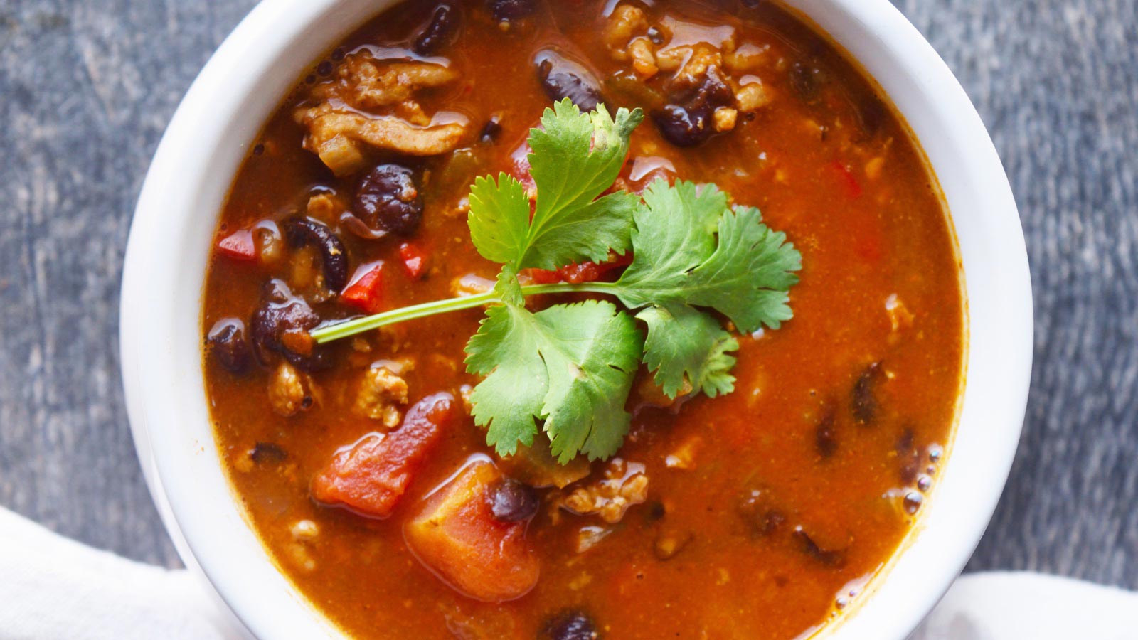 An overhead view of a white crock filled with Black Bean Taco Soup.